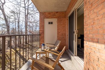A balcony with a chair and table  at Liberty Gardens Apartments, Baltimore Maryland
